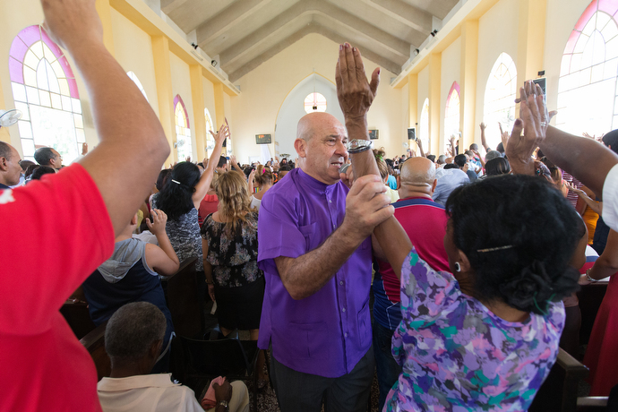Bishop Ricardo Pereira lays hands on parishioners during worship at Marianao Methodist Church. Photo by Mike DuBose, UMNS.