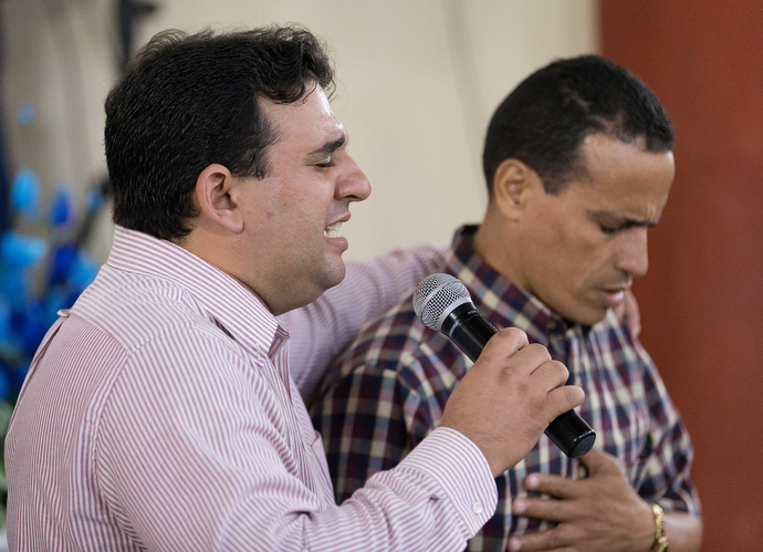 The Rev. Marcio Alcolea (left) lays hands on a parishioner during worship at the Santa Clara Methodist Church in Santa Clara, Cuba. Photo by Mike DuBose, UMNS.