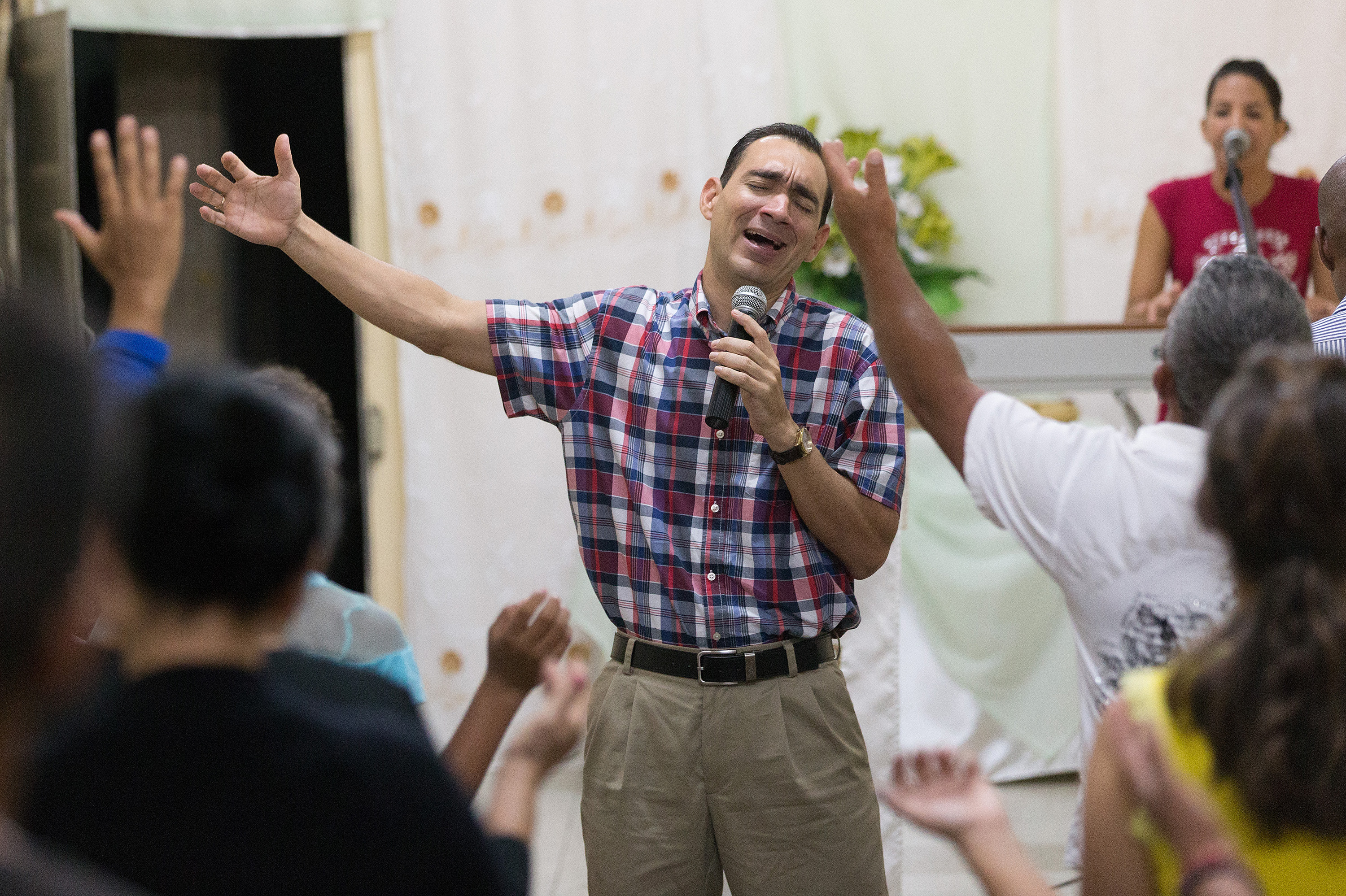 The Rev. Leandro Cordero leads a song at A Place of Hope Methodist Church in Santa Clara, Cuba. He is accompanied on the keyboard by his wife, Yenisel Ramos. Photo by Mike DuBose, UMNS.