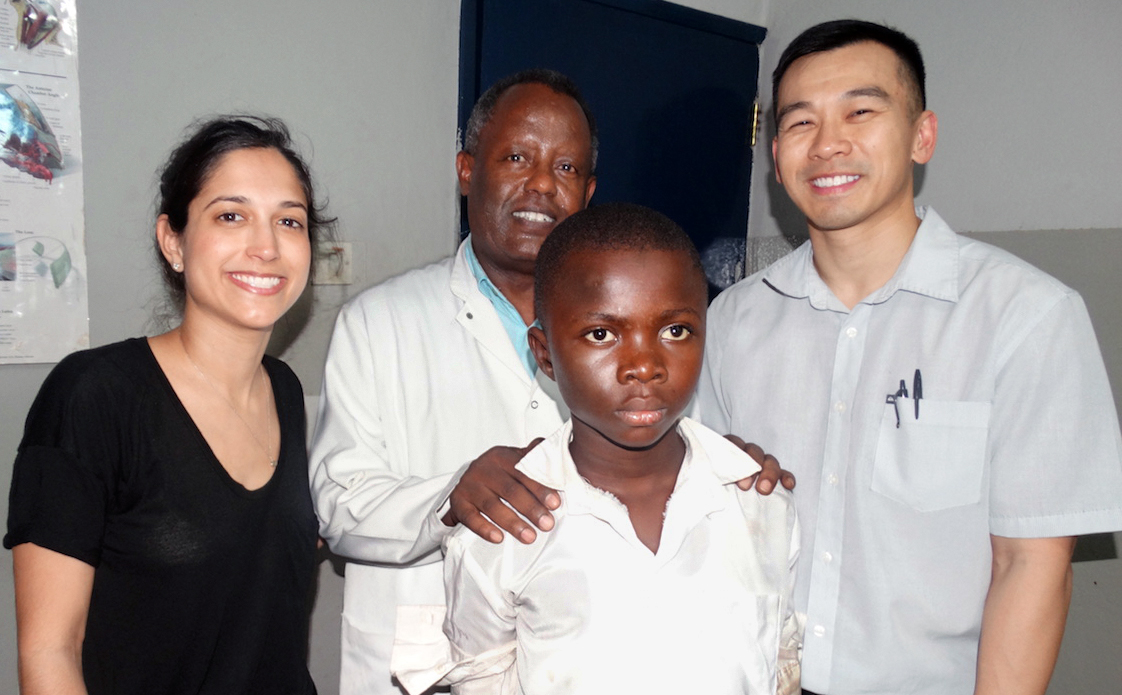 Ophthalmologists Jessica Shantha (from left), Moges Teshome and Steven Yeh pose with Umaru Sesay, 12, from Moyamba Junction, Sierra Leone. Sesay, who had cataracts as a result of contracting Ebola, had a successful operation that allowed him return to school. A partnership between Emory University and the Christian Blind Mission provides free cataract surgery to Ebola survivors at the Ruth and Lowell Gess Eye Hospital in eastern Freetown. Photo by Phileas Jusu, UMNS.