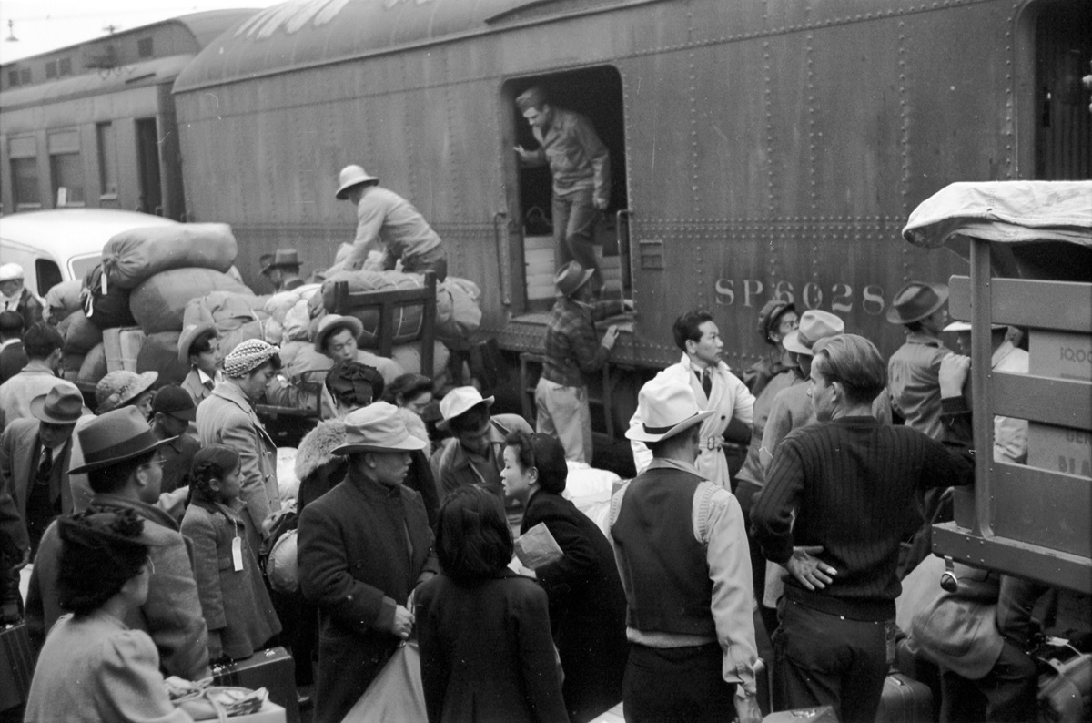 Japanese Americans going to internment camp Manzanar in Owens Valley gather around a baggage car at the old Santa Fe Station in Los Angeles, California, April 1942. Manzanar was one of 10 camps in the United States where over 110,000 Japanese Americans were forcibly removed (incarcerated) during World War II between December 1942 to 1945. 