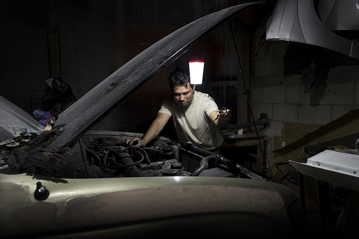 A mechanic in rural Guatemala works by the light of a d.light solar lanter. The social enterprise provides solar lighting in places without access to electricity. Photo courtesy of d.light