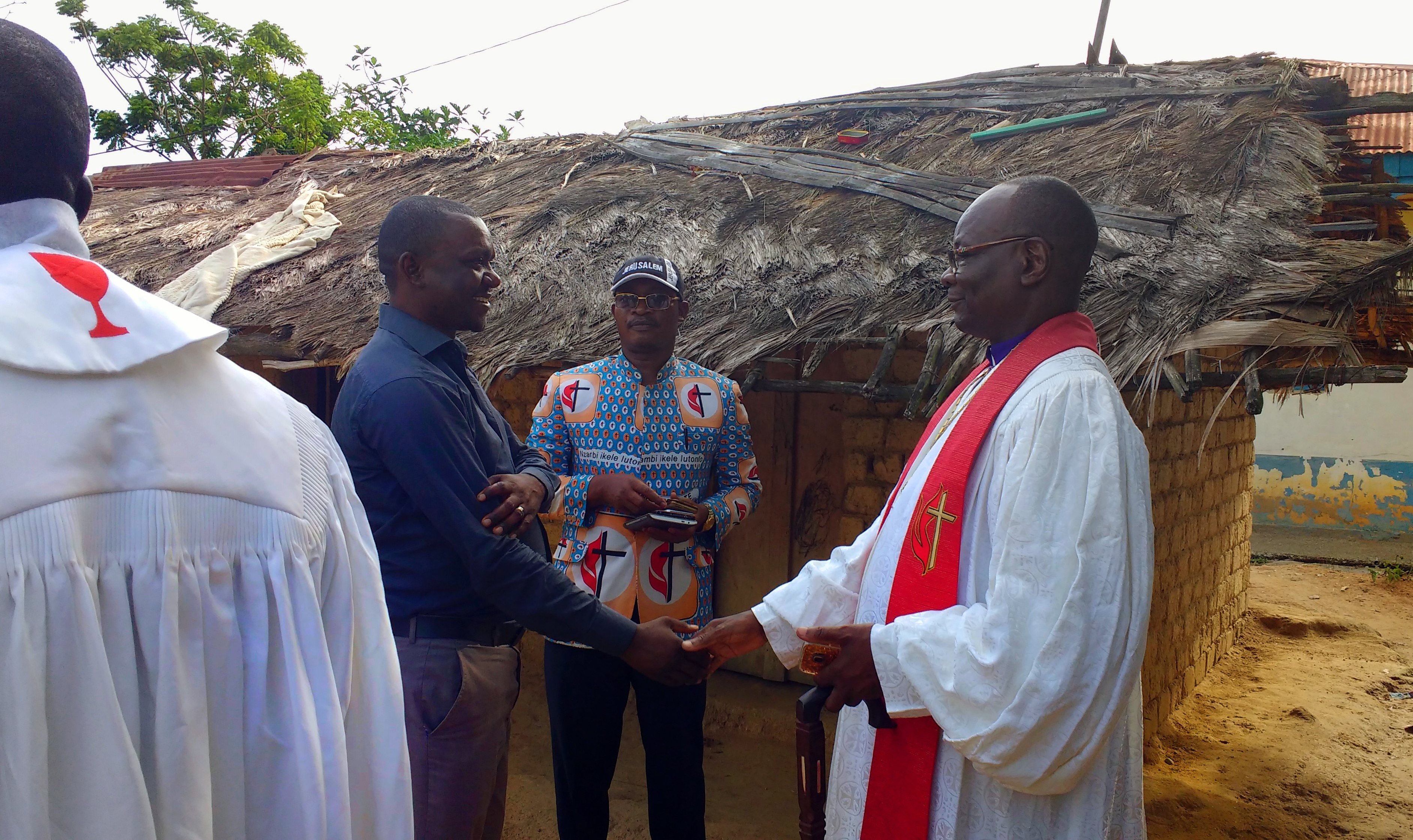 Bishop Gabriel Unda (right) greets Chief Kalema, the chief of Kalima village, as Chief Tunda, a member of the bishop's office, watches. The church, built with contributions from the Rev. Randy Cooper and others in the Memphis Conference, hosted the bishop last year. Photo by Judith Yanga, UMNS.