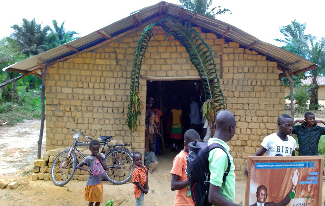 Youth in the village of Kalima in the Democratic Republic of Congo carried Bishop Gabriel Unda's picture when they came to welcome him to the new Kalima United Methodist Church. The church is the denomination’s first congregation in the area since Methodism arrived in East Congo in 1922. Photo by Judith Yanga, UMNS.
