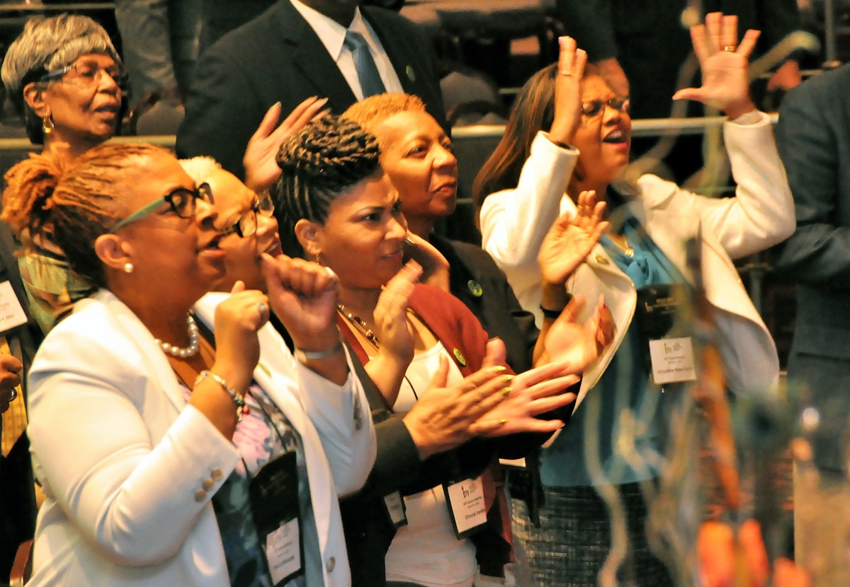Women raise their hands in praise during the BMCR annual gathering. Caucus members, spanning multiple generations, reveled in worship and fellowship. Photo by John Coleman, UMNS.