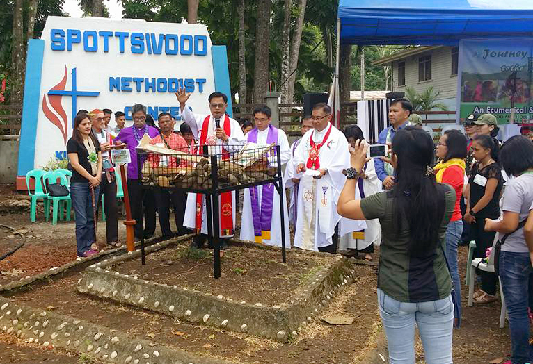 United Methodist Bishop Rodolfo Juan offers a prayer during an interfaith worship service at Spottswood United Methodist Center in Kidapawan City marking the one-year anniversary of an attack on farmers in the Philippines. Photo courtesy of Rodolfo Juan. 

