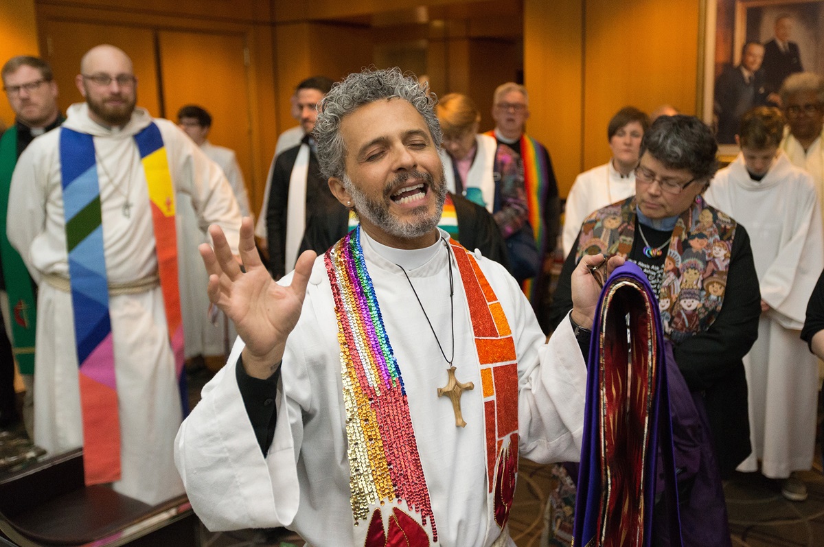 The Rev. Alex da Silva Souto of the United Methodist Queer Clergy Caucus leads a prayer prior to an oral hearing before the denomination's top court, meeting in Newark, N.J., questioning whether a gay pastor can serve as a bishop in The United Methodist Church. Photo by Mike DuBose, UMNS.