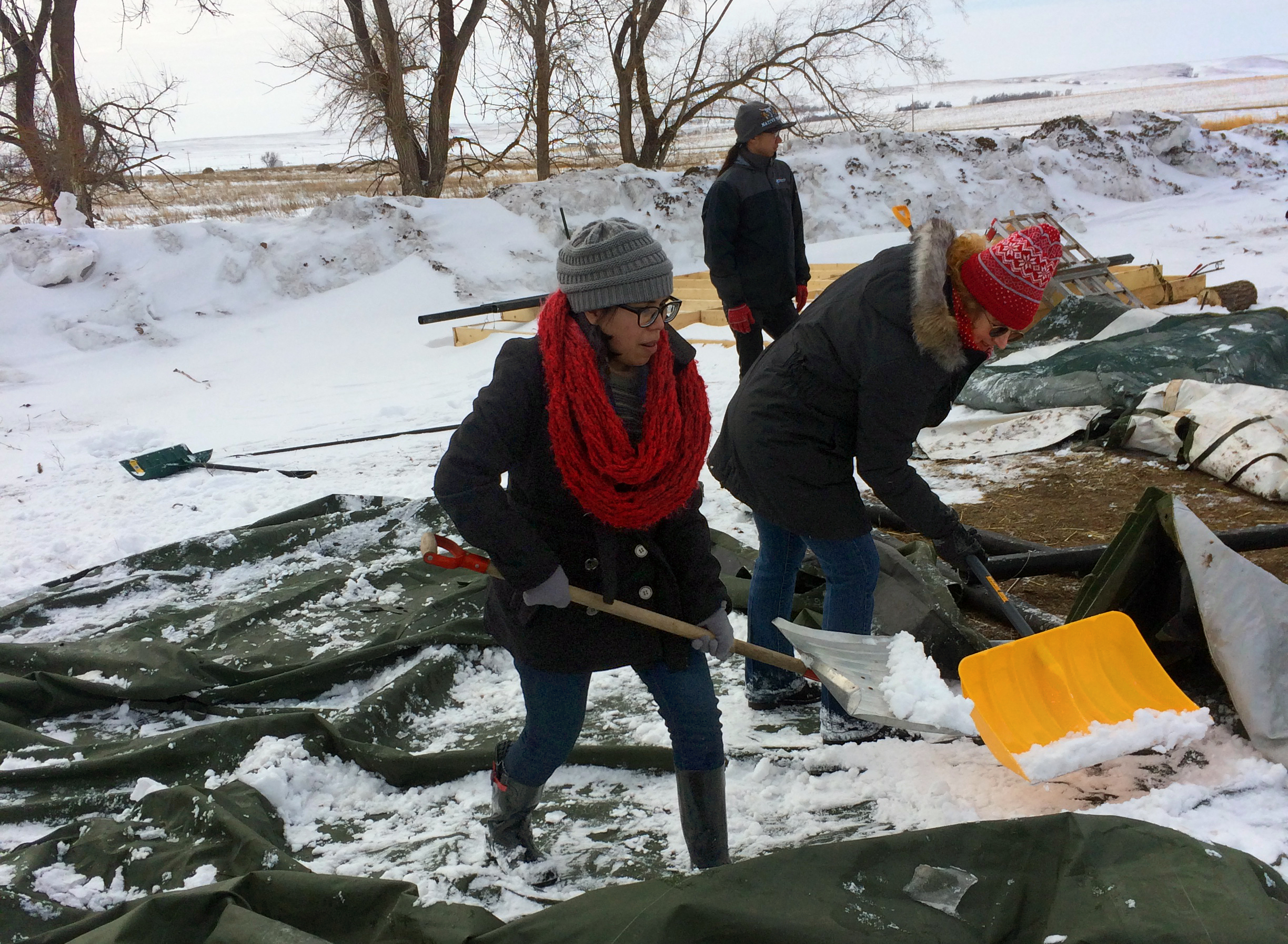 Caitlin Brown, left, a student at Oklahoma City University, and Dr. Leslie Long, right, a professor of religion at OCU, shovel snow at a camp at Standing Rock. The Rev. David Wilson, who has traveled to Standing Rock eight times, accompanied students and faculty from three Oklahoma universities during spring break to help with one of the remaining camps situated on privately owned land near the former Osceti Sakowin camp in North Dakota. Photo by the Rev. Wilson, UMNS.