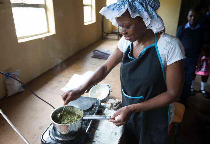 Moreblessing Nagombedze cooks chaya greens, grown on campus, during a meeting of the home management club at Chirichoga High School in Masvingo, Zimbabawe. Photo by Mike DuBose, UMNS.