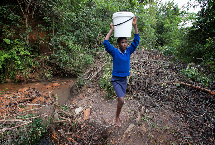 Emelly Maringire, 14, fetches water at the end of her school day. The job of fetching water falls mostly to women and girls. Photo by Mike DuBose, UMNS.