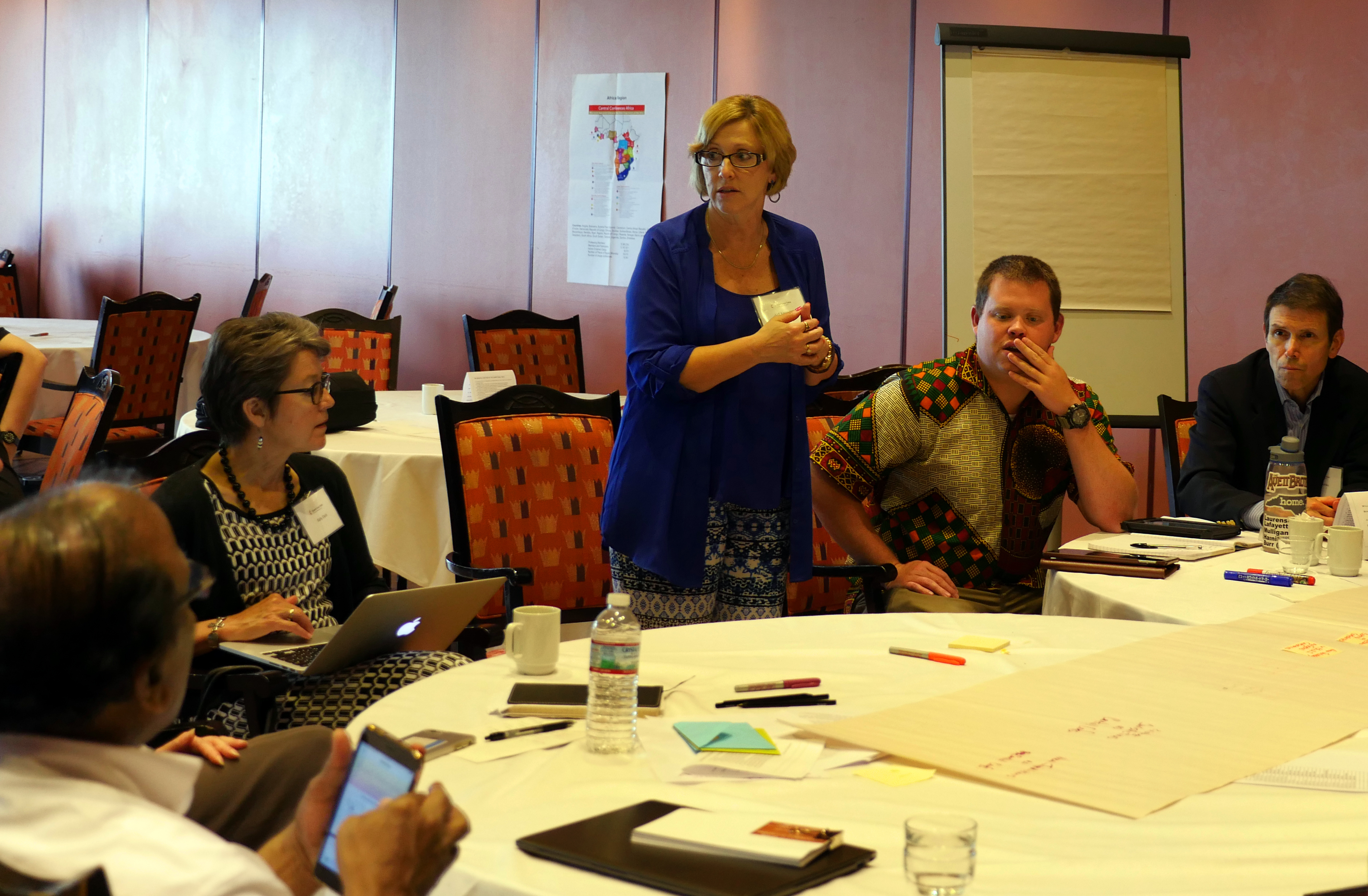 Judi Kenaston, standing, talks with members of the Connectional Table’s advisory group on U.S. matters about ideas for a new U.S. structure. Photo by Heather Hahn, UMNS.