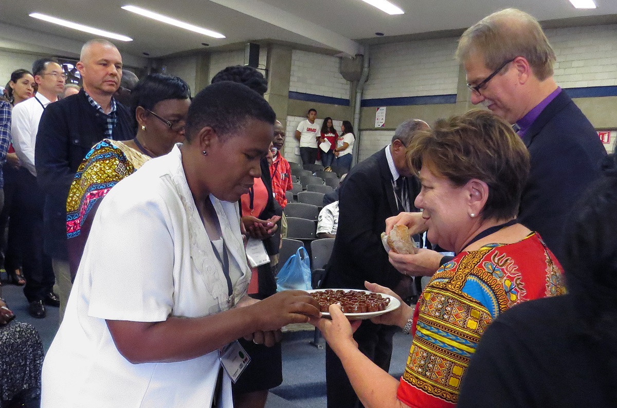 Communion was part of closing worship May 31 at the International Association of Methodist-related Schools, Colleges and Universities conference in Puebla, Mexico. Bishop Kenneth Carter (right) and the Rev. Kim Cape, top executive of the United Methodist Board of Higher Education and Ministry (second from right), serve the elements. Photo by Sam Hodges, UMNS.