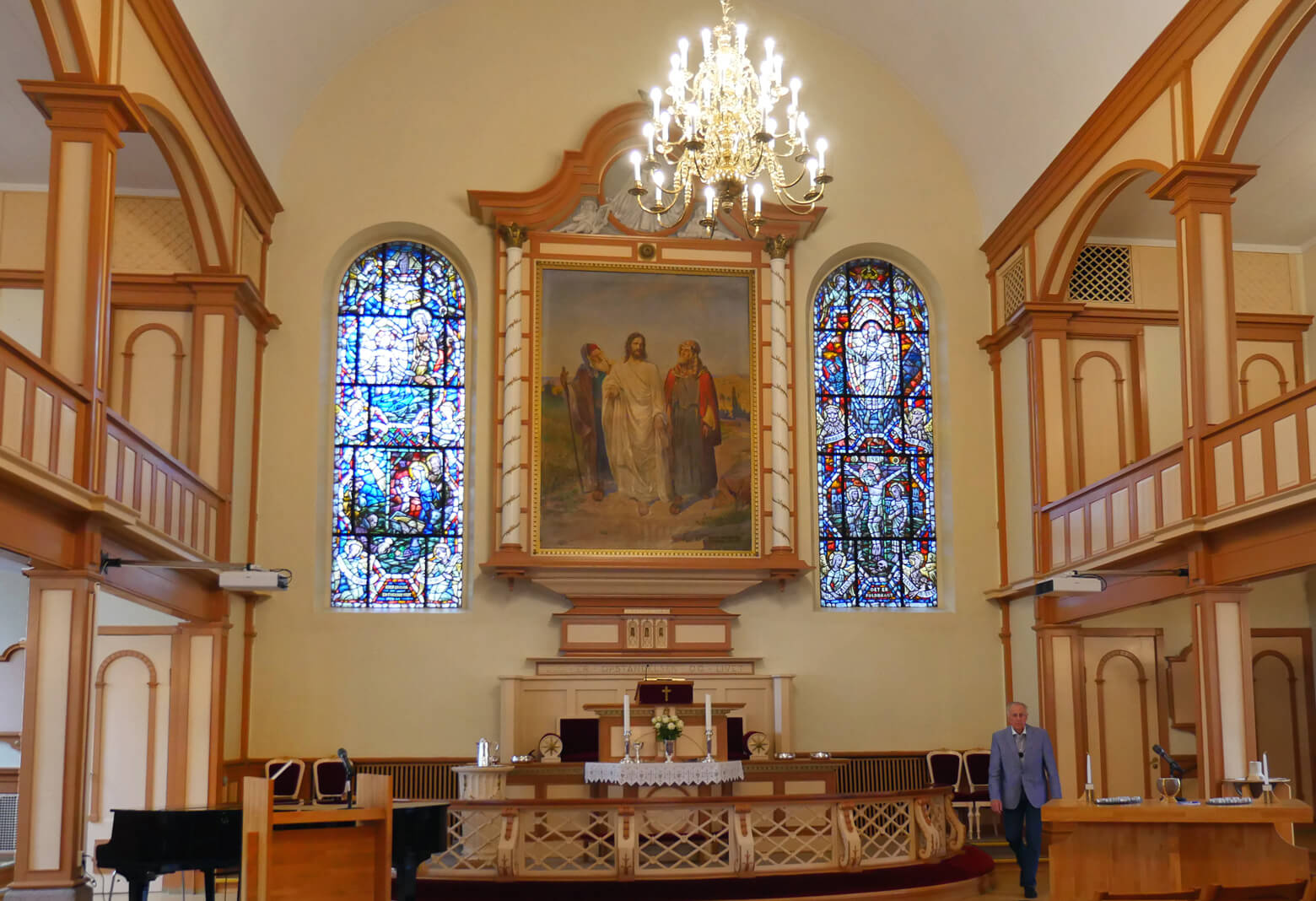 A portrait of the risen Christ, walking with two disciples on the road to Emmaus, hangs over the chancel shared by two United Methodist churches in Oslo, Norway. Photo by Heather Hahn, UMNS