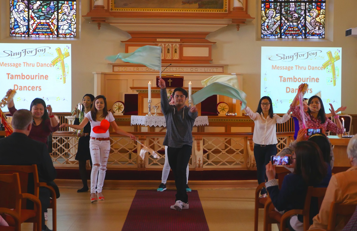 Edward Ainza, center with flags, and other members of the dance group at International Methodist Church Oslo perform a praise song during Super Sunday worship on May 21. The multicultural church, which shares space with the first United Methodist church in Oslo, is one of Norway’s fastest growing. Photo by Heather Hahn, UMNS.