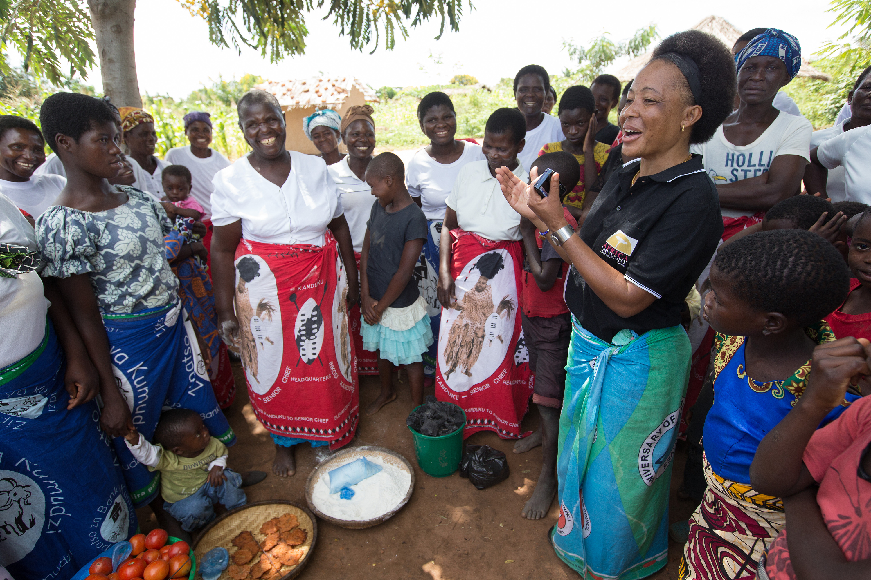 Mercy Chikhosi (in black shirt) regularly visits with the women of Nkhafi village in Malawi. She has an easy rapport with members of the village. “I developed a strong bond and a relationship so I continue visiting, influencing and motivating them to identify their needs and find solutions with local resources,” Chikhosi said. Photo by Mike DuBose, UMNS.