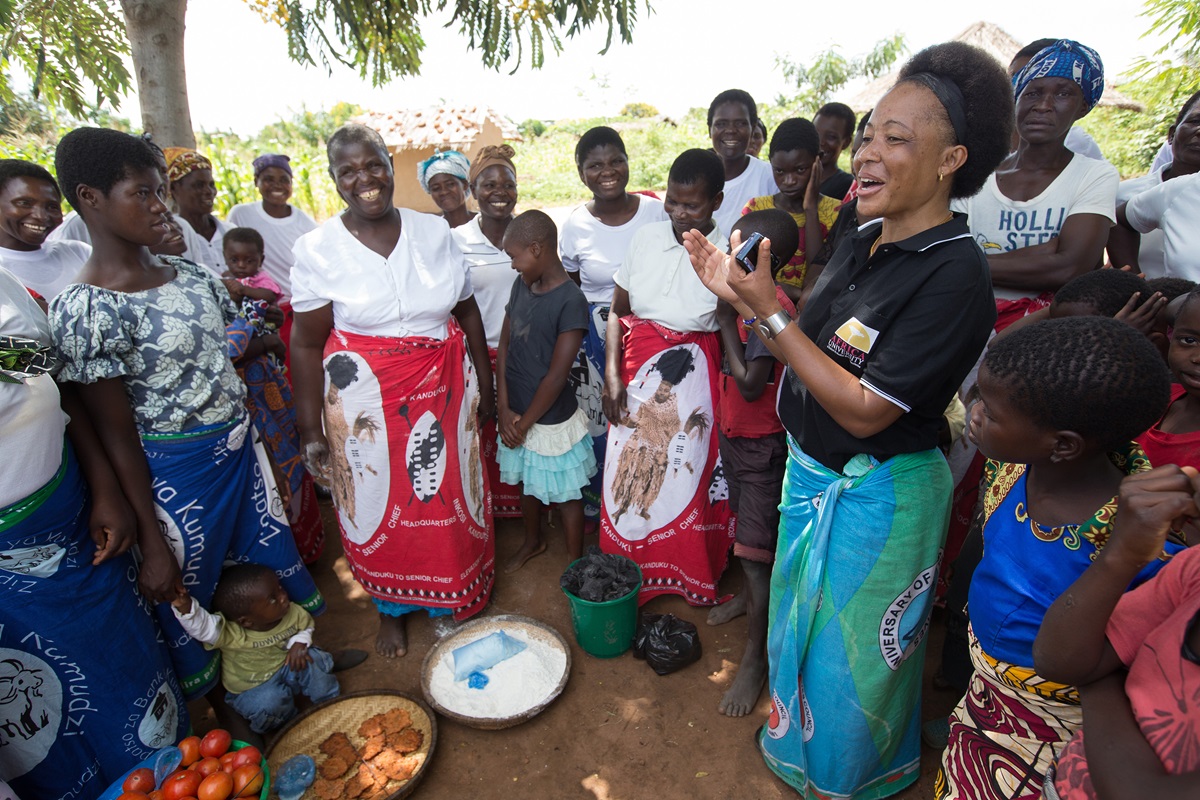 Mercy Chikhosi (in black shirt) regularly visits with the women of Nkhafi village in Malawi. She has an easy rapport with members of the village. “I developed a strong bond and a relationship so I continue visiting, influencing and motivating them to identify their needs and find solutions with local resources,” Chikhosi said. Photo by Mike DuBose, UMNS.