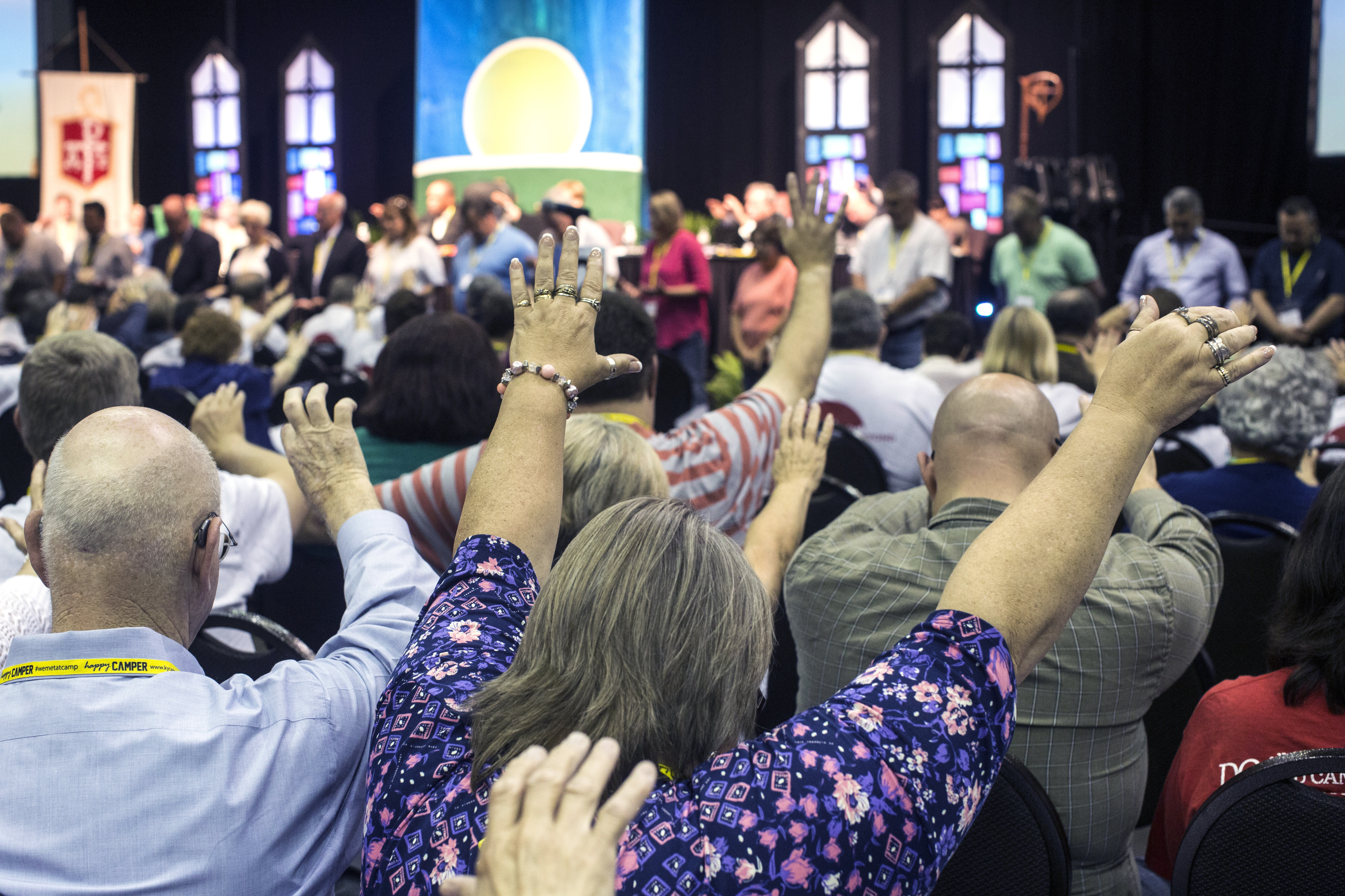 Attendees of the Kentucky Annual Conference raise their arms in prayer in the morning 