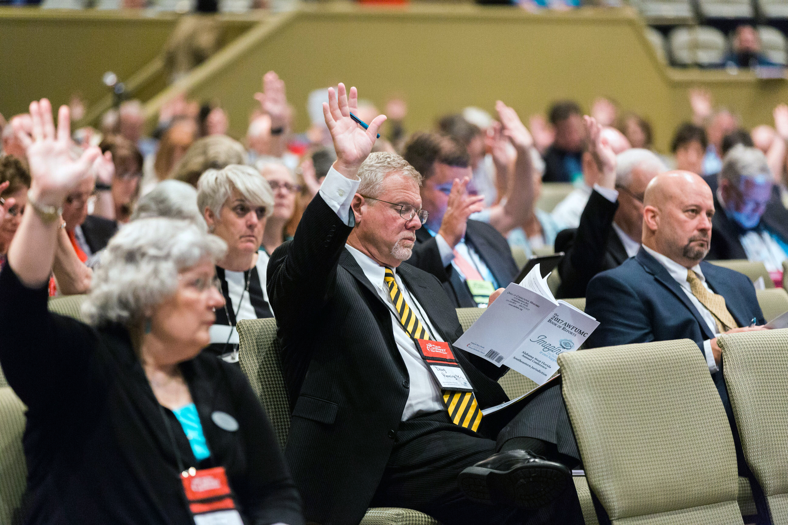 Members participate in the Alabama-West Florida Annual Conference in Montgomery, Ala., including the Revs. Nancy Watson (front row, left), Doug Pennington and Allen Newton. The conference was one of 17 that approved a resolution related to welcoming migrants. Photo by Luke Lucas, Alabama-West Florida Conference.