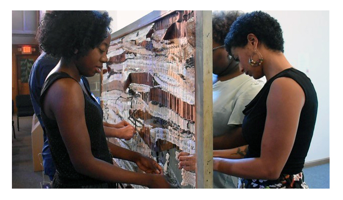 Women weave a loom of prayer at Wellspring United Methodist Church in Ferguson, Mo. The prayer loom was among the ways United Methodists across the United States addressed the violence in Charlottesville, Va. Photo courtesy of the Rev. F. Willis Johnson.