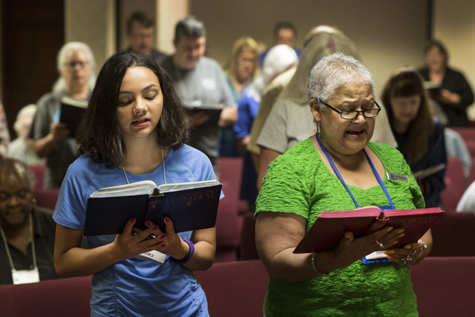 Sade Jones (left) and Connie Locklear sing during the opening worship. Photo by Kathleen Barry, UMNS.