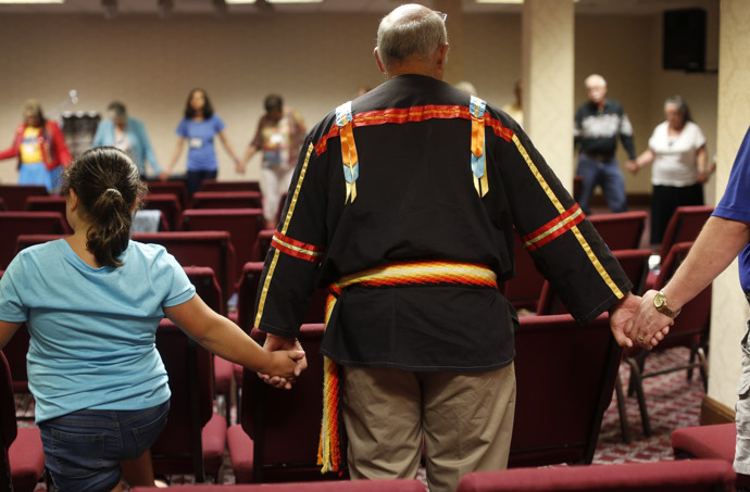 Conference attendees join hands in a circle of prayer. Photo by Kathleen Barry, UMNS.