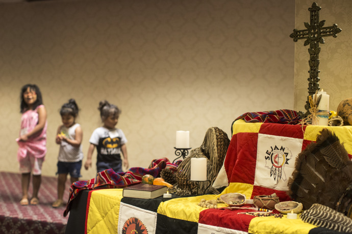 A display at the conference features symbolism of faith and Native American culture. Behind the table, descendants of the Lumbee tribe represent the future. Photo by Kathleen Barry, UMNS.