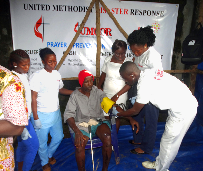 Osman Jalloh receives medical treatment at the United Methodist Disaster Response booth in the Pentagon community in Freetown, Sierra Leone. Osman was the only survivor in his home when the building collapsed under pressure from the landslide that killed nearly 500 people. Photo by Phileas Jusu, UMNS.
