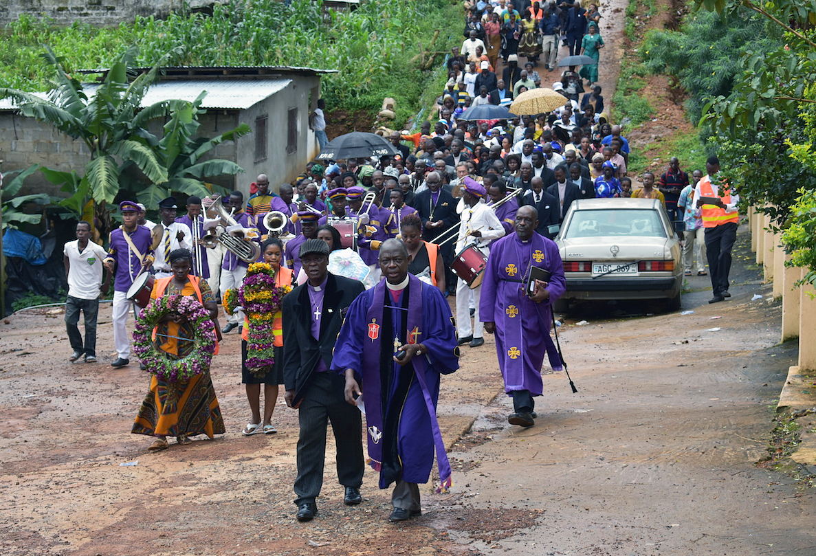 Clergy from the Council of Churches of Sierra Leone lead a procession of worshippers to an area at the bottom of Mount Sugar Loaf where hundreds of bodies that were not recovered are still buried under the rubble of a devastating landslide. A service of remembrance and thanksgiving for the victims and survivors was held at the bottom of Mount Sugar Loaf, Aug. 27. Photo by Phileas Jusu, UMNS.