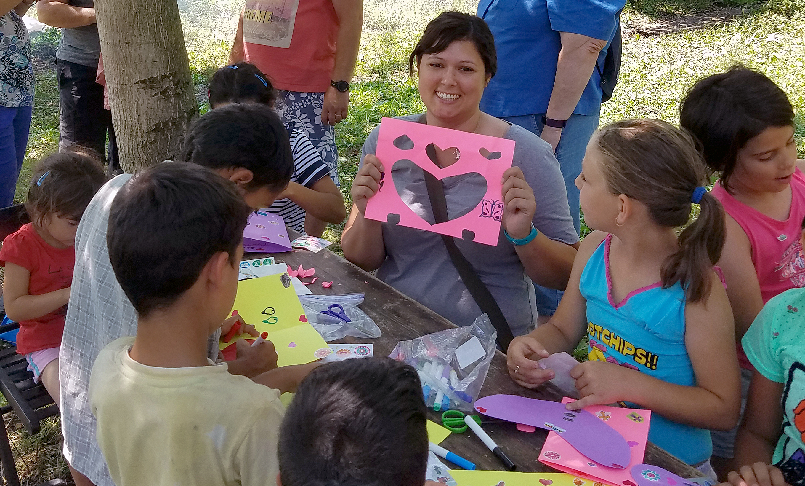 Nicole Tipton, center, a member of First Centenary United Methodist Church in Chattanooga, Tennessee, leads an arts-and-crafts session this summer with Roma children in Comsesti, Romania, on a plot of land owned by United Methodists there.  Photo by Barry Kidwell.