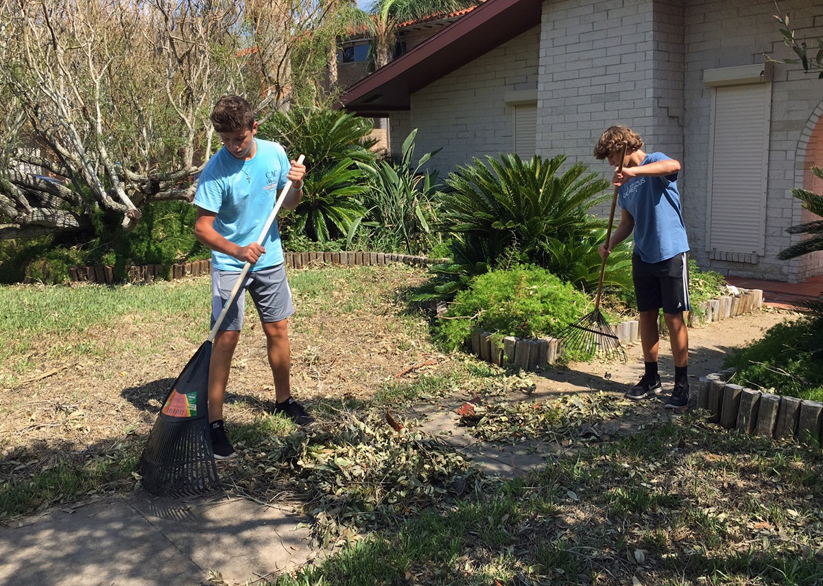 Two teens from First United Methodist Church in Corpus Christi, Texas, rake and remove debris after Hurricane Harvey devastated areas of Texas with winds and flooding. Youth from the church conducted clean ups in both Corpus Christi and Portland. Photo courtesy of Whitney Hendley.
