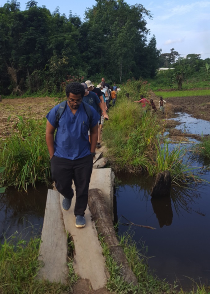 Dr. Shane Sam Mathew (front) leads a visit to a farm near Ganta United Methodist Hospital in Liberia. The 25-year-old dentist was killed in a fire at his residence. Photo courtesy of Ganta United Methodist Hospital.