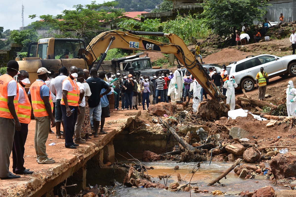 Workers recover a body from beneath a bridge in Kamayama, Sierra Leone, nearly two weeks after flooding and mudslides killed hundreds. United Methodist Bishop John Yambasu was at the site when the body was found and expressed hope that the tragedy would teach every Sierra Leonean a hard lesson and result in better programs to relocate people from at-risk areas. Photo by Phileas Jusu, UMNS.