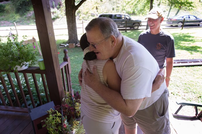 The Rev. Jack Lipphardt (center) gets a hug from homeowner Janet Osborne whose house near Clay, W. Va., was damaged by flooding. Lipphardt, who helps oversee disaster response for the West Virginia Conference of The United Methodist Church, was checking on a volunteer team from South Roanoke (Va.) United Methodist Church that is helping with repairs. At rear is the Rev. J.F. Lacaria, executive director for disaster recovery for the conference. Photo by Mike DuBose, UMNS.