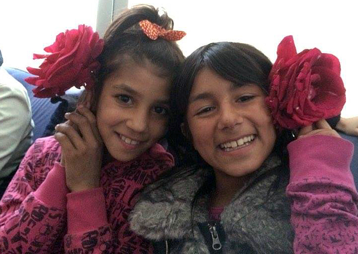 Two Roma children pose with flowers and smile during an excursion in a mini-bus. They are part of a school project sponsored by The United Methodist Church in Macedonia. Photo courtesy of Christina Cekov.
