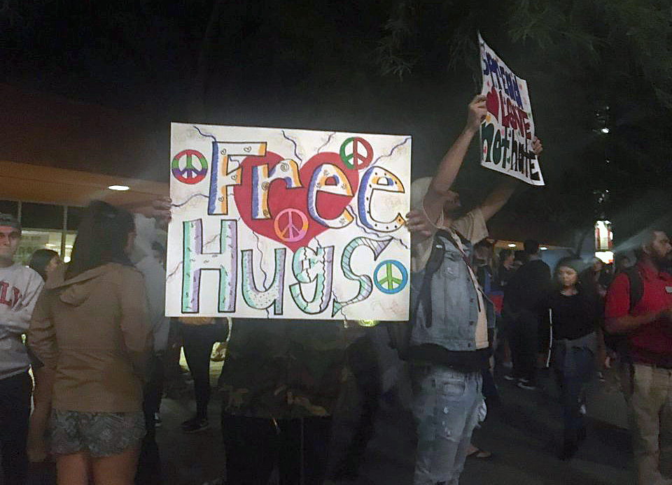 Students hold signs of support at a ministry booth on the campus of University of Nevada, Las Vegas, in response to the Oct. 1 shooting massacre. The site of the mass shooting was close to campus dormitories and students heard sirens of emergency response vehicles through the night. The student ministry offered a safe listening space as care for fellow students. Photo by Susan Holden, courtesy of Desert Southwest Conference.