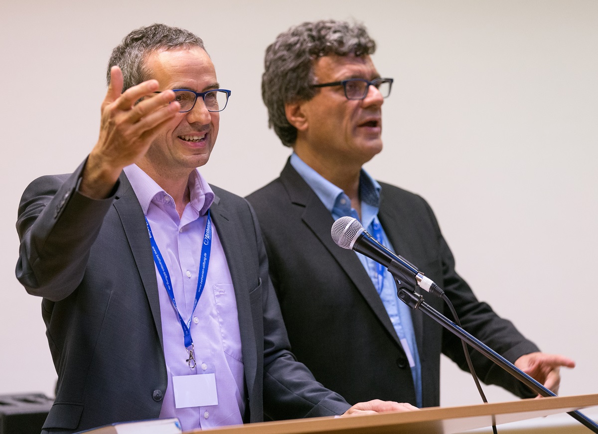 The Rev. Lothar Elsner (left) and Thomas Kemper welcome participants to the International Health Forum of The United Methodist Church in Stuttgart, Germany. Elsner is president of the Bethany Deaconess Foundation in Frankfurt and Kemper is top staff executive of the denomination's Board of Global Ministries. Photo by Mike DuBose, UMNS.