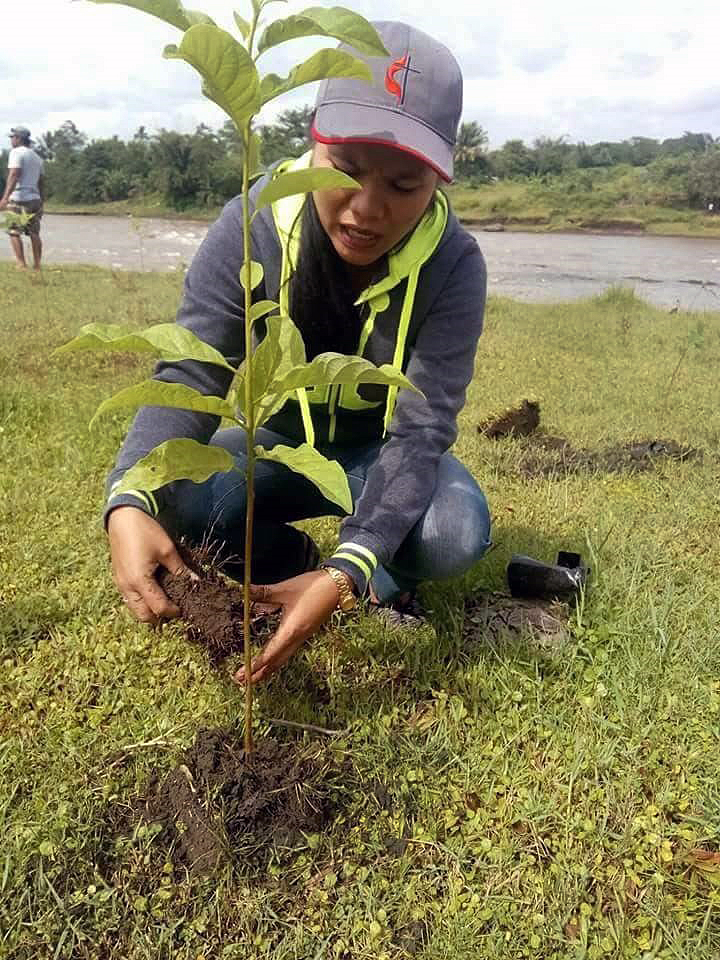 A participant in a tree-planting project in the Davao area of the Philippines kneels to settle a sapling in the soil. Church members and leaders joined in the tree-planting along the Pulangi River. Photo courtesy of the Rev. Rogemer Sison.