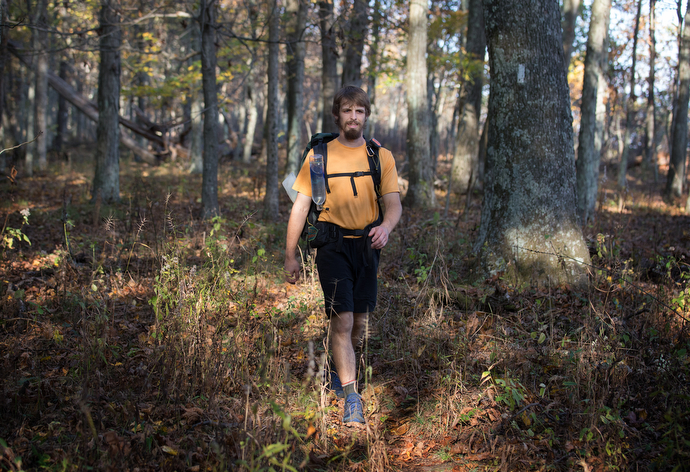 The Rev. Matt Hall hikes on the Appalachian Trail near Pearisburg, Va. White blazes like the one on the tree at right mark the 2,200-mile route from Maine to Georgia.