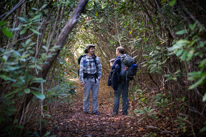 The Rev. Matt Hall (left) visits with a fellow hiker inside a rhododendron grove along the Appalachian Trail near Bland, Va.