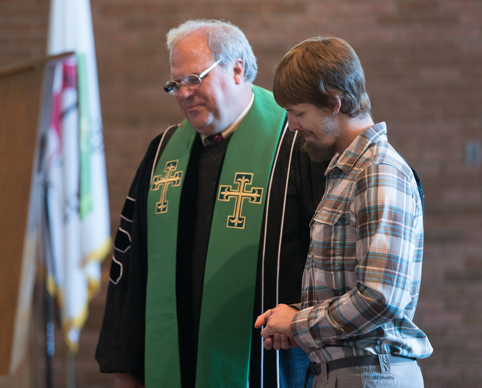 The Rev. Brian Burch (left) of First United Methodist Church in Pearisburg, Va., prays with the Rev. Matt Hall during worship at the church.