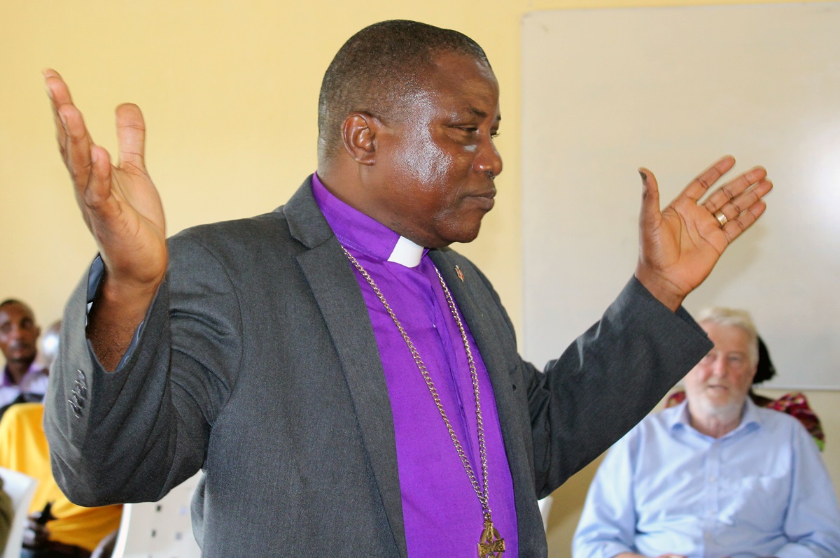 Bishop Samuel J. Quire Jr., raises his hands during regular devotion at the United Methodist Church in Liberia’s central office on Oct. 27. The bishop is calling on all Liberians to shun violence as they prepare for a run-off presidential election. 