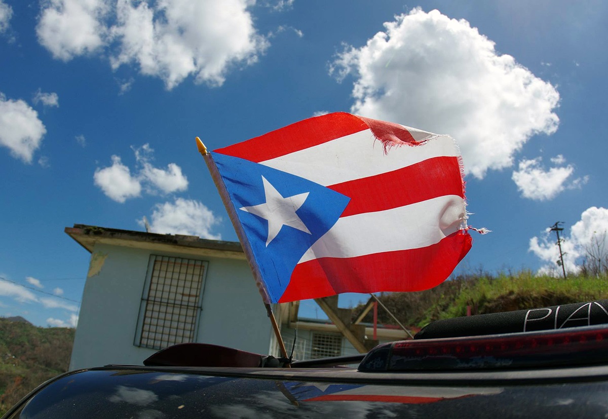A torn flag of Puerto Rico waves from a car a week after Hurricane Maria ravaged the island. Photo by the Rev. Gustavo Vasquez, UMNS.