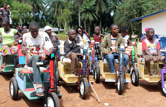 Recipients of Personal Energy Transportation vehicles pose with their new modes of transportation. The United Methodist Women in Liberia distributed the wheelchairs. Photo by Julu Swen, UMNS.