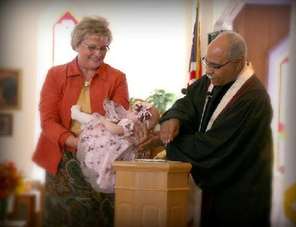 Margie Briggs and the Rev. Cody Collier baptize a child during a worship service. Photo courtesy of Margie Briggs.