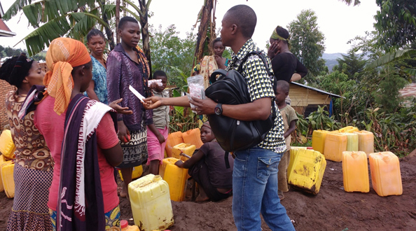 United Methodist volunteers distribute water purification tablets at a watering point in Kavumu, Democratic Republic of Congo. Unsafe drinking water has led to a cholera epidemic in the South Kivu Province. Photo by Philippe Kituka Lolonga, UMNS.