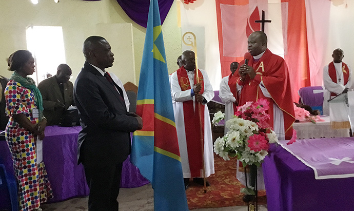 North Katanga Area Bishop Mande Muyombo invites Professor Jackson Mwenzeni to pray at the Shalom Convention in Kamina, Democratic Republic of Congo. The group prayed for peace for the government, the community and the country. United Methodists are planning several other prayer events around the country in the coming weeks. Photo by Betty Kazadi Musau, UMNS.