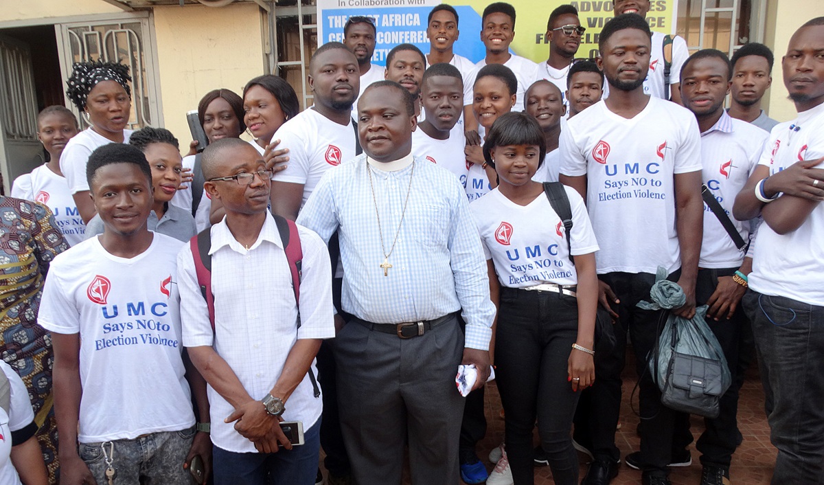 The Rev. Sylvester Holima (center) organizes United Methodist young adults at UMC House, the home office of the Sierra Leone Conference, in Freetown, as they prepare to take the No Election Violence Campaign on the road. Regional missionary Finda Quiwa (standing, back left, in black head dress) funded the two-day campaign. Photo by Phileas Jusu, UMNS.
