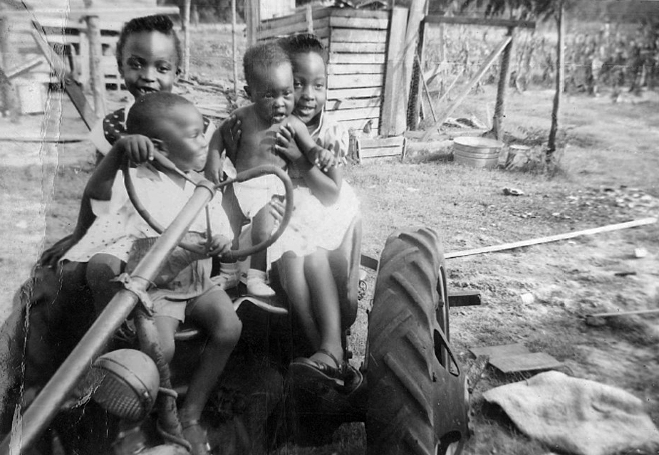 James H. Salley sits in the driver seat of a tractor as a child in 1957 surrounded by three of his sisters. Salley, who grew up on his family’s farm in Allendale County, S.C., has established a scholarship at Africa University in honor of his hardworking parents, Marie and James Salley. Photo courtesy of James H. Salley.