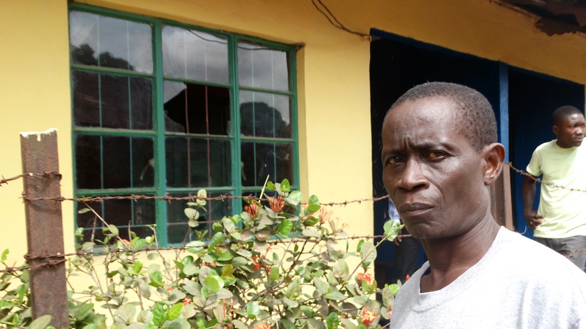 The  Rev. Ndapi Saffa, pastor at Rogers Memorial United Methodist Church in Bo, southern Sierra Leone,  stands by a broken window at his home after a wave of violent post-election attacks on the community. Saffa, his wife and two children were under siege until a rescue team arrived to ward off the attackers. Photo by Phileas Jusu, UMNS.