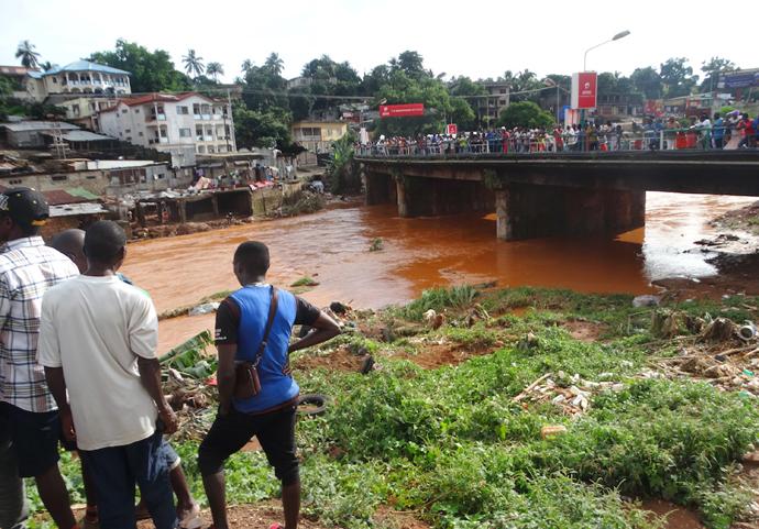 Volunteers wait at Wallace Johnson Bridge to spot and recover bodies in the aftermath of a mudslide and flooding at Sugar Loaf Mountain in Freetown, Sierra Leone. Photo by Phileas Jusu, UMNS.  